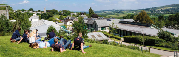 Students sitting on the grass at a sunny Stoke Climsland